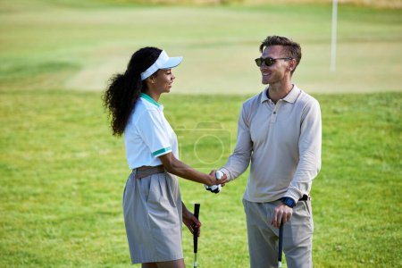 Photo for Portrait of two golf players shaking hands on green field after enjoying game match - Royalty Free Image