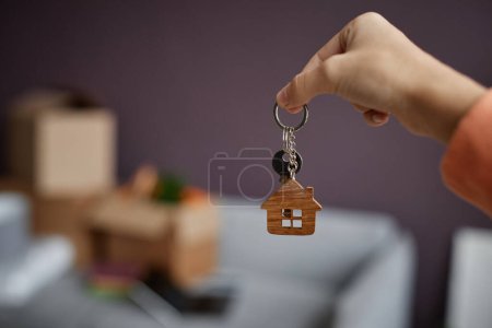 Téléchargez les photos : Gros plan de la jeune femme tenant les clés dans sa main, elle les obtient du nouvel appartement - en image libre de droit