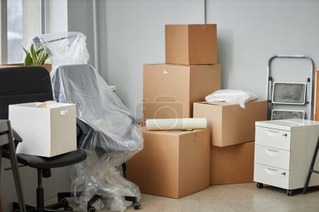 Téléchargez les photos : Déménagement dans un nouveau bureau avec des boîtes en carton emballées et des meubles - en image libre de droit
