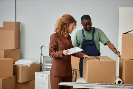 Photo for Young businesswoman discussing conditions for moving with worker and signing the contract - Royalty Free Image