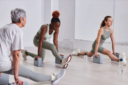 Téléchargez les photos : Groupe de personnes faisant des exercices pendant l'aérobic dans un club de santé - en image libre de droit
