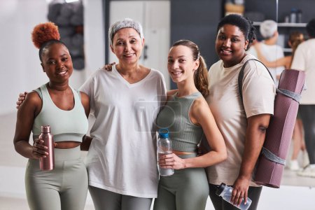 Photo for Portrait of group of women smiling at camera together standing in health club after sport training - Royalty Free Image