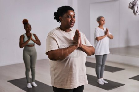 Téléchargez les photos : Groupe de femmes en surpoids faisant du yoga ensemble pendant la formation dans un club de santé - en image libre de droit