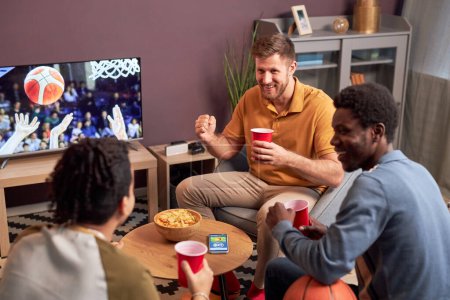Foto de Vista de ángulo alto en el grupo de fanáticos de los deportes viendo el partido en casa en la televisión y animando - Imagen libre de derechos