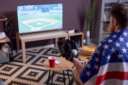 Foto de Vista lateral de los fanáticos de los deportes viendo el partido de béisbol en casa en la televisión y con bandera de Estados Unidos, espacio para copiar - Imagen libre de derechos