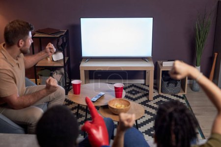 Foto de Grupo de fanáticos de los deportes emocionales viendo el partido en la televisión con la pantalla en blanco maqueta - Imagen libre de derechos