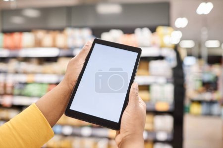 Photo for Closeup of female hands holding tablet with blank white screen mockup in supermarket, shopping list or website, copy space - Royalty Free Image