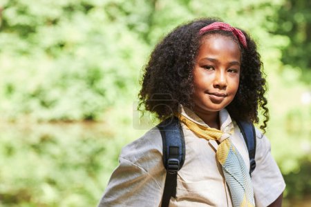 Foto de Cintura hacia arriba retrato de linda chica negra como niña exploradora mirando a la cámara al aire libre en el bosque, espacio de copia - Imagen libre de derechos