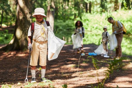 Photo for Full length portrait of cute black boy as scout cleaning forest during eco awareness field trip, copy space - Royalty Free Image