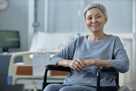 Photo for Portrait of senior woman looking at camera sitting in wheelchair during her rehabilitation in hospital - Royalty Free Image