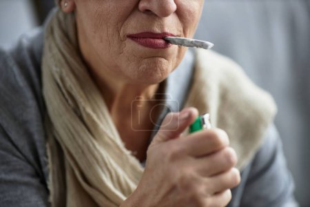 Foto de Primer plano de la mujer adulta encendiendo el cigarrillo fumar con fines terapéuticos y tratamiento médico - Imagen libre de derechos