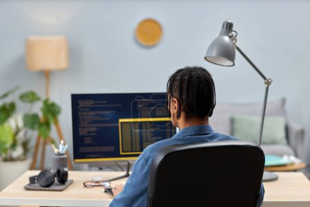 Téléchargez les photos : Vue arrière du code d'écriture professionnel informatique masculin tout en travaillant sur le lieu de travail de bureau, espace de copie - en image libre de droit