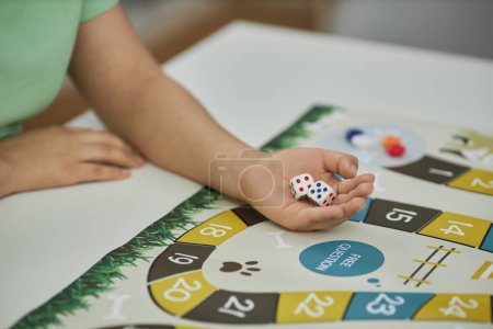 Photo for Closeup of unrecognizable young woman ready to throw dice while playing board game with friends, copy space - Royalty Free Image