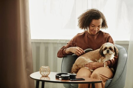 Foto de Retrato franco de una joven negra cepillando perro mascota mientras disfrutan del tiempo juntos en casa, espacio para copiar - Imagen libre de derechos