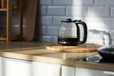 Téléchargez les photos : Gros plan de cafetière en verre avec café frais à l'intérieur debout sur la table dans la cuisine - en image libre de droit
