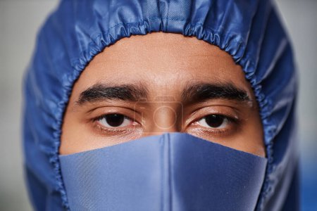 Photo for Macro shot of medical worker wearing full protective gear looking at camera over mask - Royalty Free Image