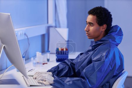 Photo for Side view portrait of young male scientist using computer while doing research in laboratory, copy space - Royalty Free Image