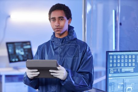 Photo for Waist up portrait of young male scientist wearing full protective suit in laboratory and looking at camera - Royalty Free Image