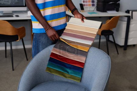 Foto de Primer plano del diseñador afroamericano examinando muestras de textiles durante su trabajo en el cargo - Imagen libre de derechos