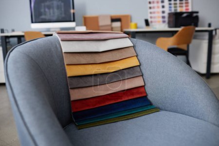 Téléchargez les photos : Gros plan des échantillons de textile coloré pour l'intérieur couché sur le fauteuil dans le bureau - en image libre de droit