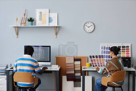 Téléchargez les photos : Vue arrière du plan de dessin du concepteur sur ordinateur avec son collègue examinant le motif coloré à la table - en image libre de droit