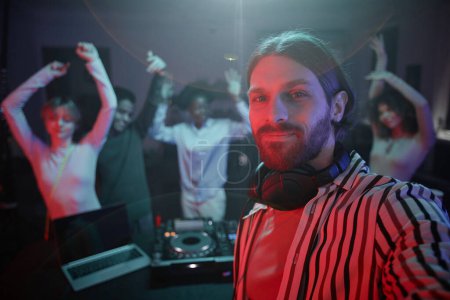 Foto de POV de DJ de pelo largo tomando foto selfie en la fiesta retro disco con gente bailando en el fondo, espacio para copiar - Imagen libre de derechos