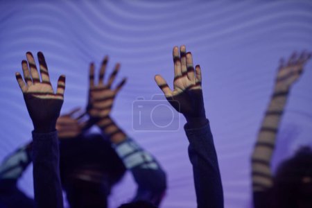 Foto de Primer plano de las manos de la gente bailando en la fiesta disco iluminada por luces de neón, espacio para copiar - Imagen libre de derechos