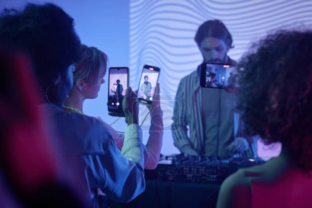 Téléchargez les photos : Groupe de jeunes filmant DJ à une soirée disco avec smartphones - en image libre de droit