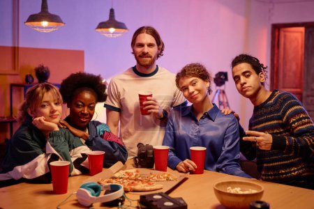 Téléchargez les photos : Groupe diversifié de jeunes regardant la caméra à la maison fête style années 80 - en image libre de droit