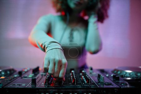 Foto de Primer plano de la mujer joven como DJ encender los interruptores de la batidora en el club nocturno, espacio de copia - Imagen libre de derechos
