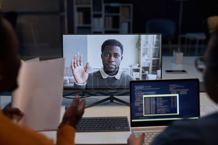 Téléchargez les photos : Programmeurs discutant du programme informatique avec un collègue en ligne lors d'une réunion numérique au bureau - en image libre de droit