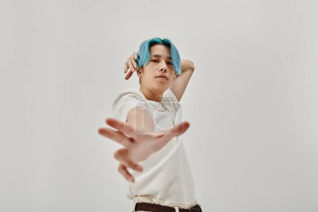 Téléchargez les photos : Asiatique jeune danseur avec des cheveux bleus exercice sur fond blanc - en image libre de droit