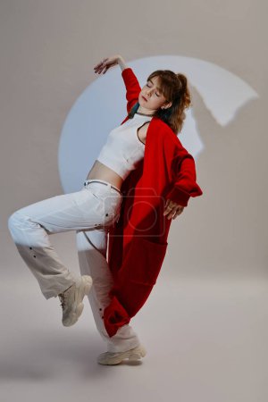 Imagen vertical de la joven en rojo disfrutando de su baile sobre fondo blanco