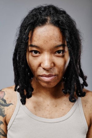 Photo for Vertical portrait of black young woman with no makeup and real skin texture looking at camera confidently - Royalty Free Image