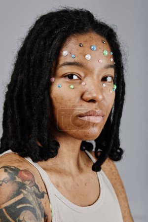 Photo for Vertical portrait of ethnic young woman with tattooes looking at camera - Royalty Free Image