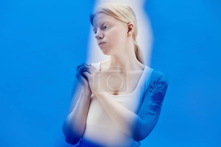 Photo for Minimal portrait of young woman with albinism posing in color blue, copy space - Royalty Free Image