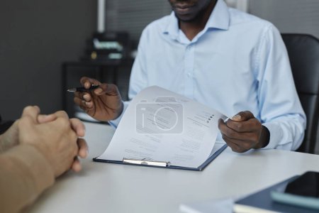 Foto de Primer plano del hombre negro como reclutador de recursos humanos revisando CV durante la entrevista de trabajo, espacio de copia - Imagen libre de derechos