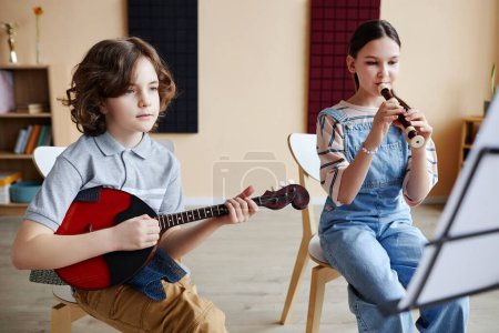Téléchargez les photos : Les enfants apprennent à jouer des instruments de musique pendant les cours de musique - en image libre de droit