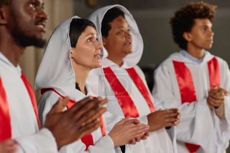 Foto de Gente del coro de la iglesia de pie en fila aplaudiendo y cantando - Imagen libre de derechos