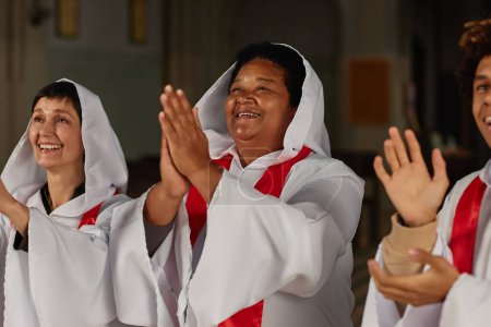 Téléchargez les photos : Groupe de personnes heureuses applaudissant en chantant dans la chorale dans l'église baptiste - en image libre de droit