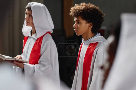 Téléchargez les photos : Groupe de personnes du choeur de l'église lisant la prière en se tenant debout dans l'église baptiste - en image libre de droit