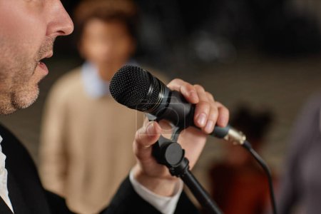 Téléchargez les photos : Gros plan du pasteur mature parlant au microphone à l'église - en image libre de droit