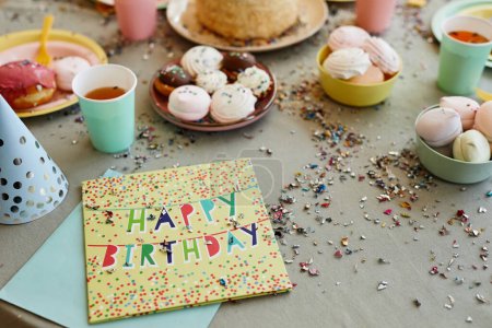 Foto de Imagen de fondo de la tarjeta de cumpleaños feliz con purpurina y confeti en la mesa de la cena con dulces durante la fiesta de cumpleaños para los niños, espacio para copiar - Imagen libre de derechos