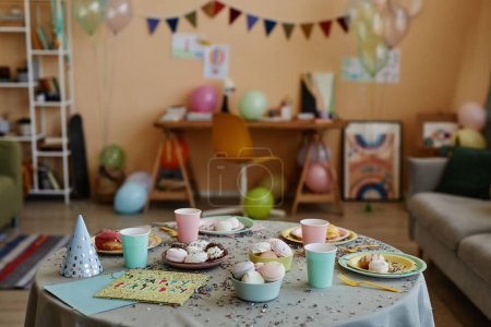Téléchargez les photos : Image de fond de la chambre d'enfant colorée décorée pour la fête d'anniversaire avec accent sur la table à manger avec des bonbons et des paillettes, espace de copie - en image libre de droit
