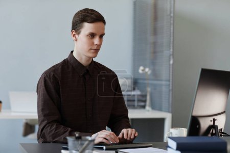 Foto de Retrato de un joven usando un ordenador en un lugar de trabajo de oficina limpio, espacio para copiar - Imagen libre de derechos