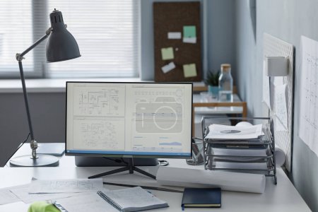 Téléchargez les photos : Image de fond du lieu de travail des ingénieurs dans le bureau avec des plans sur l'écran d'ordinateur, espace de copie - en image libre de droit