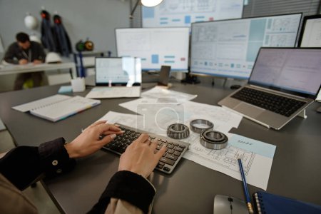 Téléchargez les photos : Gros plan d'une ingénieure qui utilise un ordinateur sur son lieu de travail au bureau en mettant l'accent sur la dactylographie, l'espace de copie - en image libre de droit