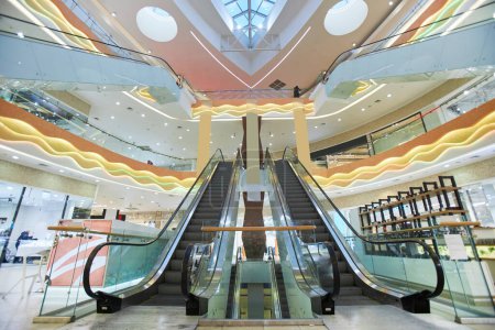 Téléchargez les photos : Dramatique vue grand angle de l'intérieur du centre commercial avec accent sur escaliers escaliers roulants copier l'espace - en image libre de droit