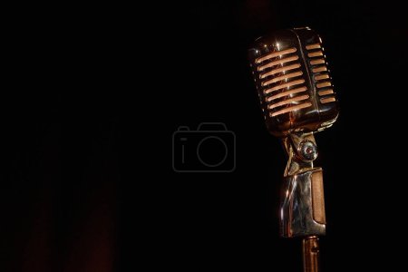 Photo for Close up of retro microphone on stage with black background copy space - Royalty Free Image