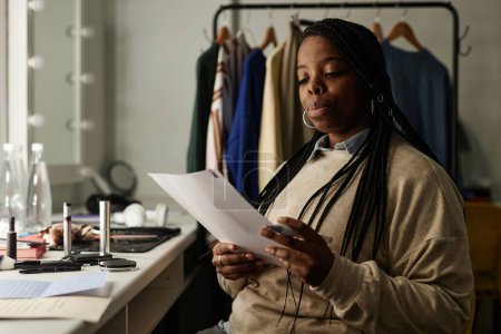 Téléchargez les photos : Portrait de femme afro-américaine lignes de lecture se préparant pour la performance dans l'espace de copie dressing - en image libre de droit